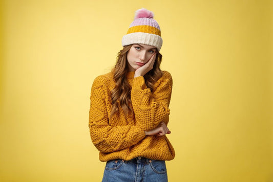 A girl wearing a beanie. There is a yellow background.