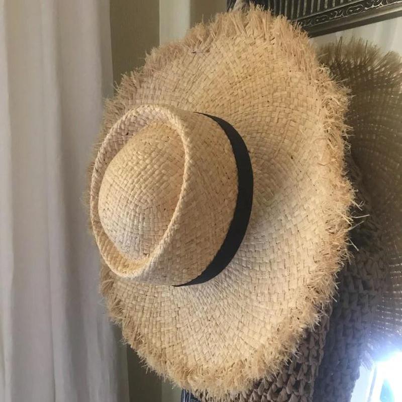 wide brim sun hat with hat hanging on wall