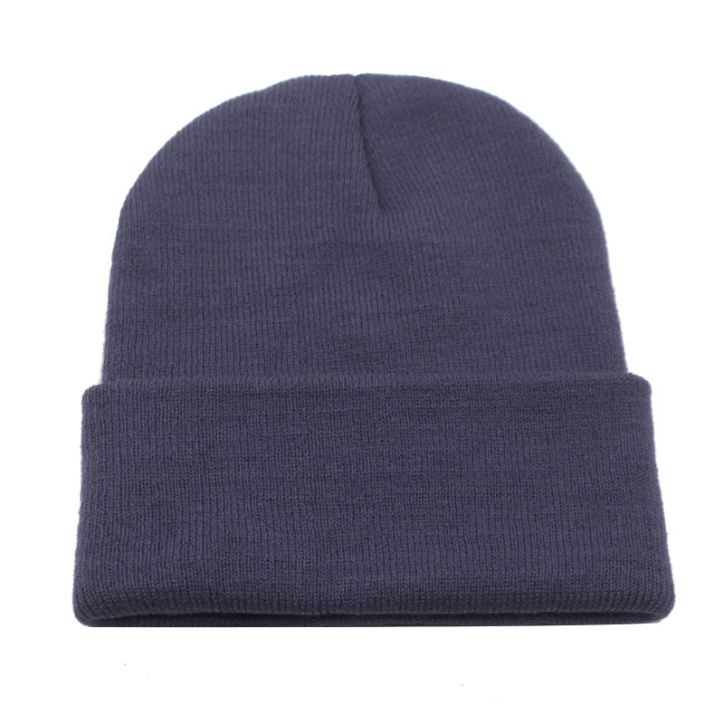 essential beanie in navy laying flat on white background 