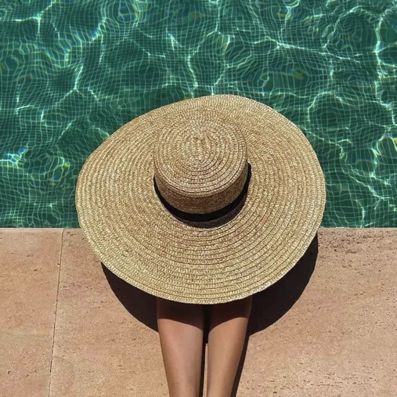 straw beach hat on a model in the pool showing top of hat 