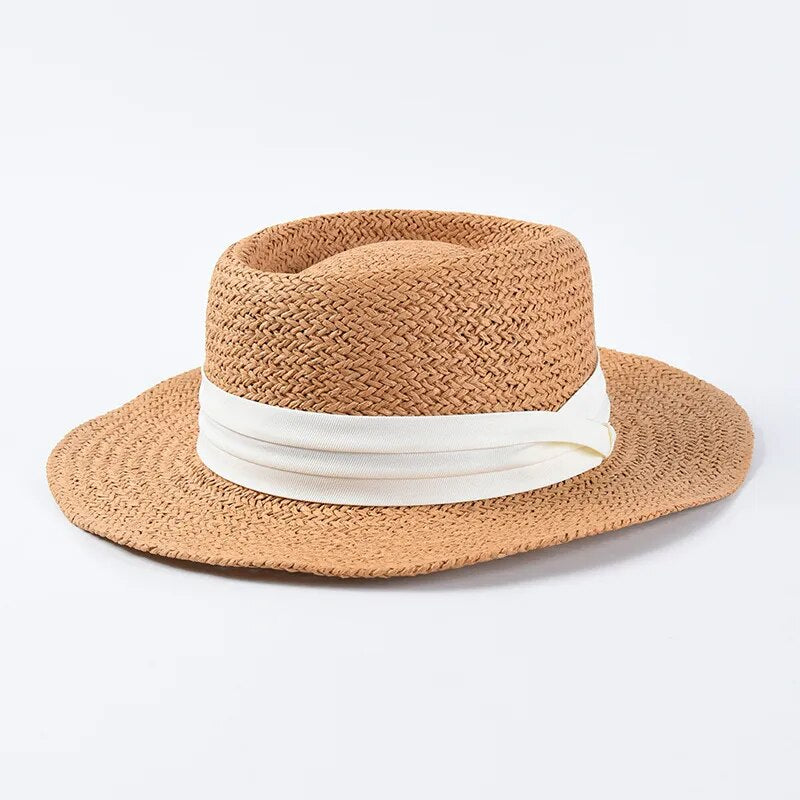 straw sun hat with white ribbon on brown colored hat 