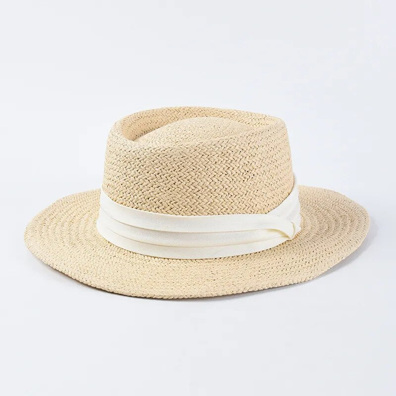 straw sun hat with white ribbon on light colored hat 