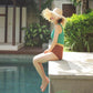 gardening hat on model sitting by a pool