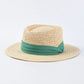 straw sun hat with green ribbon on light colored hat 