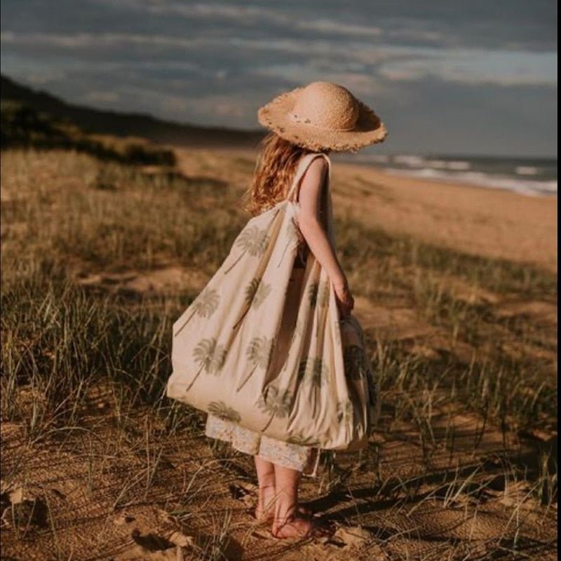 cute straw hat on a child at the beach in grass 