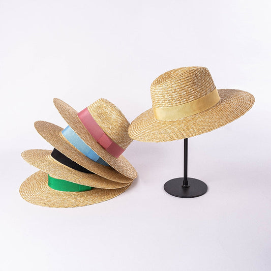 straw hat with ribbon with 1 hat on stand and the other hats stacked on each other