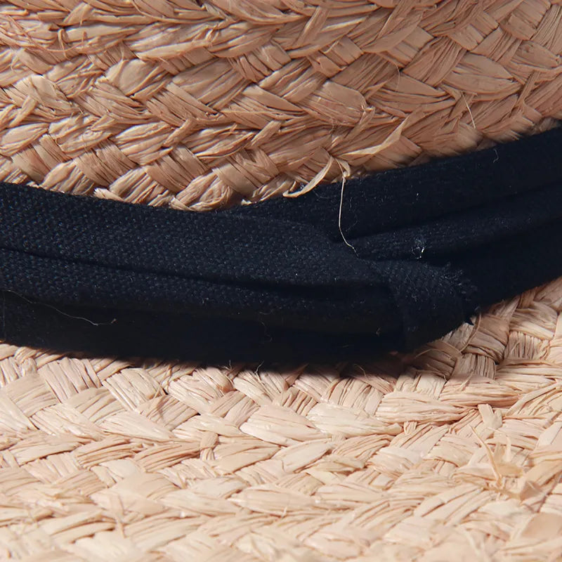summer straw hat showing closeup of black ribbon 