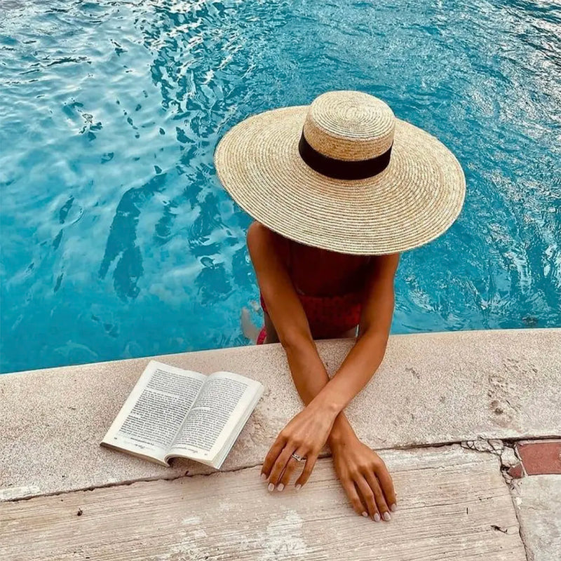 straw beach hat on model in pool showing top of hat
